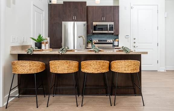 A kitchen with a bar stool and a counter.