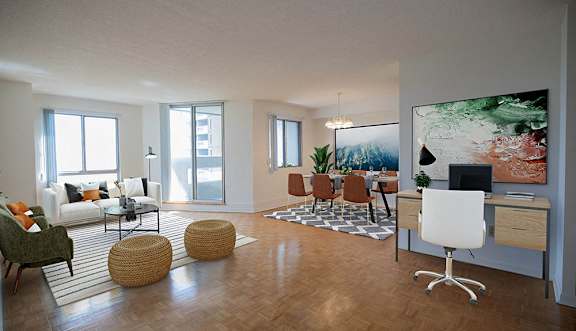 A living room with a grey sofa, a wooden coffee table, and a dining table set up in the background.