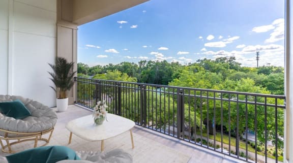 a balcony with a view of trees and a blue sky