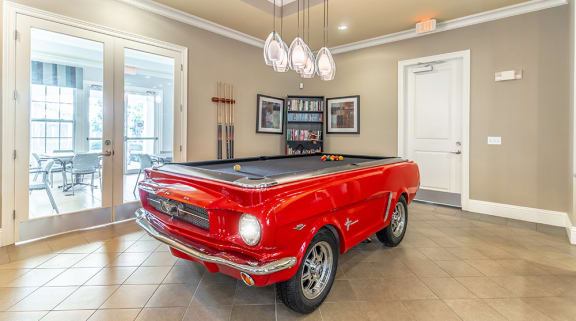 a red pool table with a black top in the middle of the room
