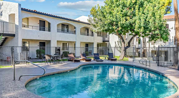 A small pool in a courtyard surrounded by a black fence. at Tides on East Cactus Apartments, Arizona