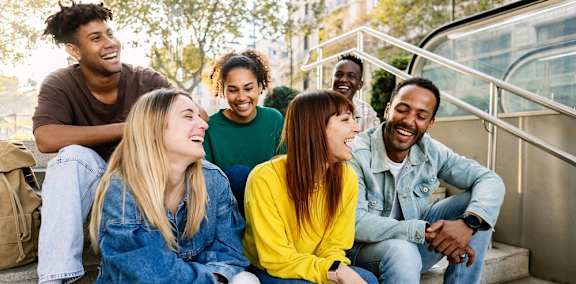 group of multicultural friends sitting together in a park
