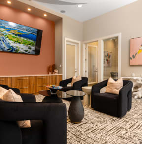a living room with couches and chairs and a tv on the wall at Miro at the Parc, Henderson, NV
