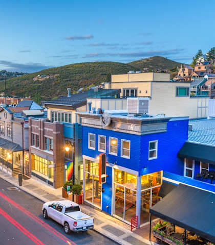 A street view of a town with buildings and cars.