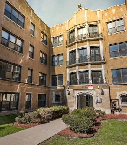 A courtyard surrounded by brick buildings with a walkway in the middle.