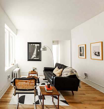 a living room with white walls and a black couch