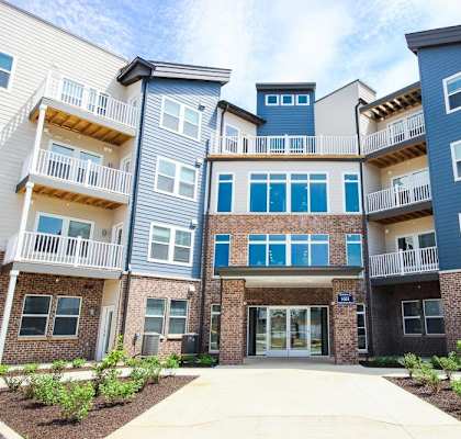 A modern apartment complex with multiple balconies and doors.