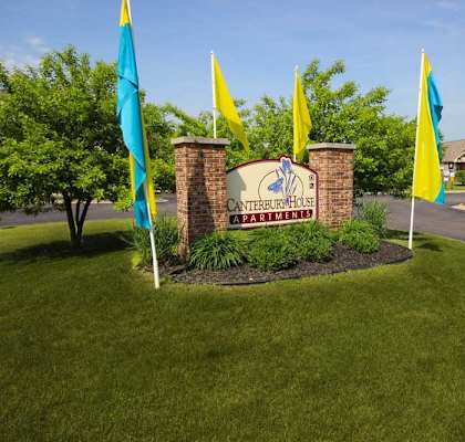 a park with flags and a sign in the grass