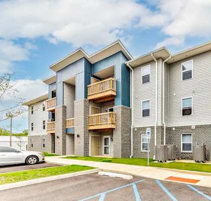 Apartment building with a car parked in front.