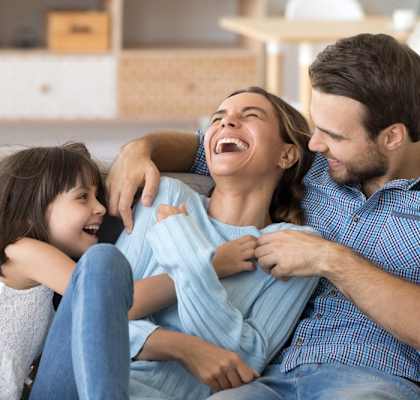 a man and woman sitting on a couch with a daughter