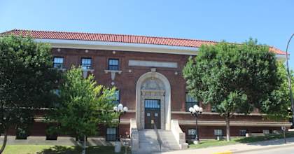 A red brick building with a large arched entrance and a sign above it.