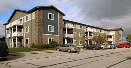 Apartment building with cars parked in front.