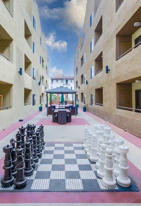 A giant chess board is set up in the courtyard of a building.