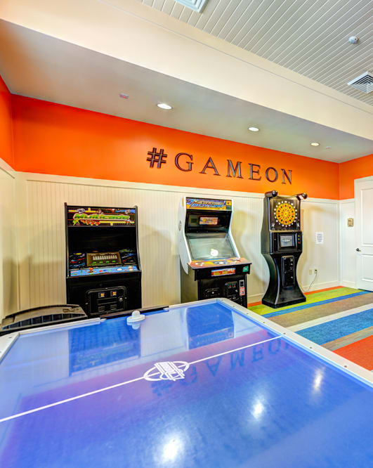 a recreation room with arcade games and a ping pong table at Hacienda Club Apartments in Jacksonville, FL