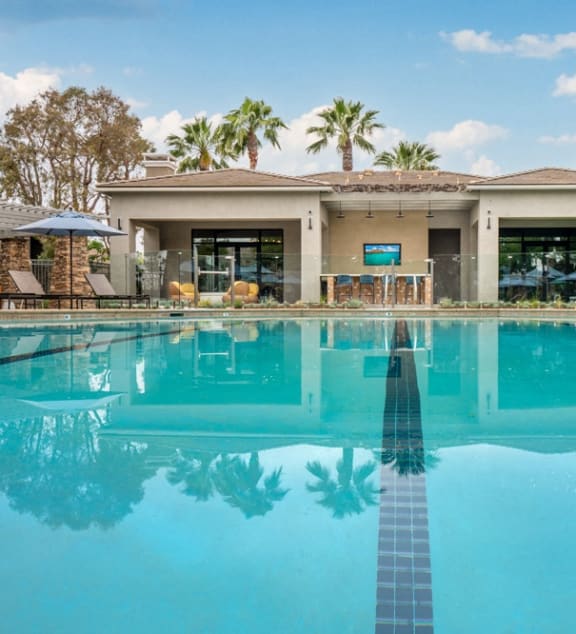 a large swimming pool with a house in the background