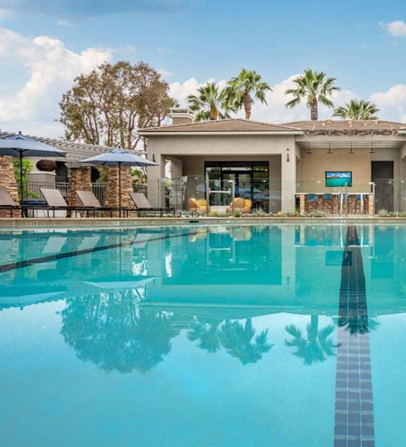 a large swimming pool with a house in the background
