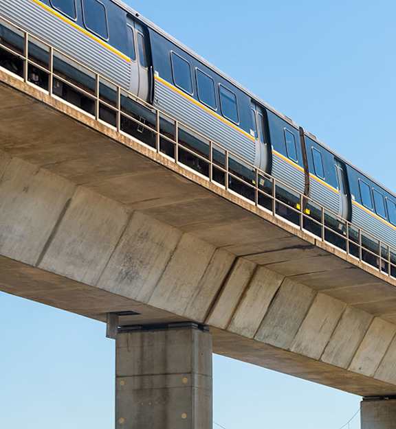 A train is traveling on a concrete bridge.