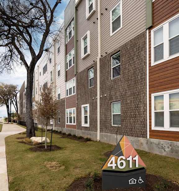 Apartment building with a car parked in front.