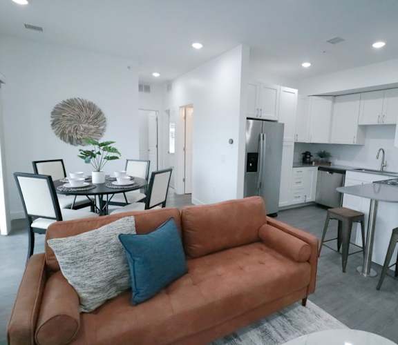 a living room and kitchen with a couch and a table