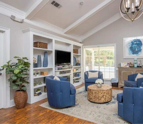 A living room with blue chairs and a wooden floor.