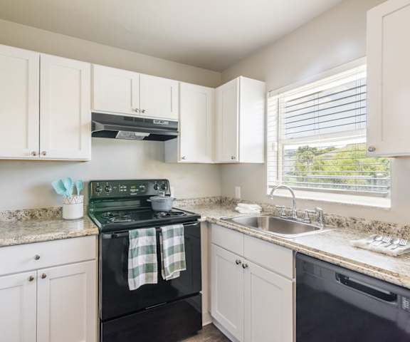 Apartment kitchen with white cabinets and black appliances, Rolling Hills Apartments