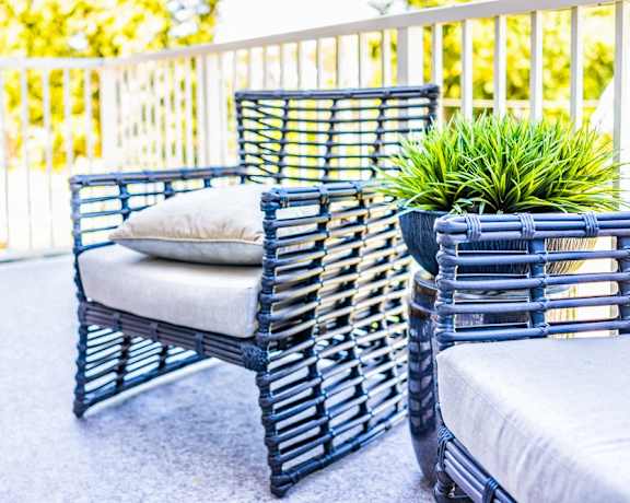 a pair of chairs and a cushion on a patio
