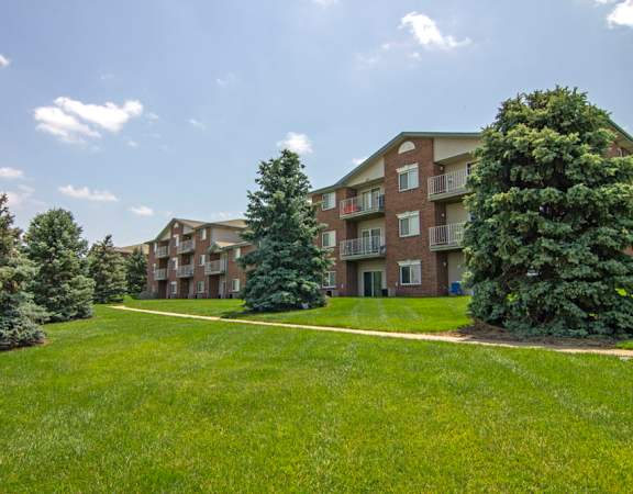 an apartment building with green grass and trees