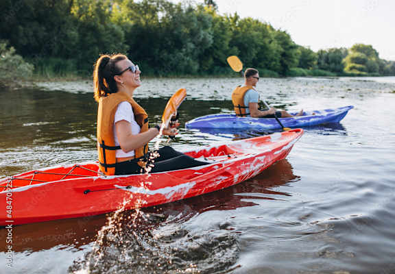 Two people kayaking on a river.