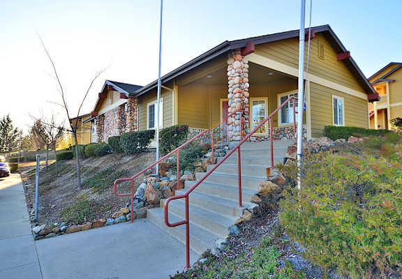 A house with a stone pillar and red railings.