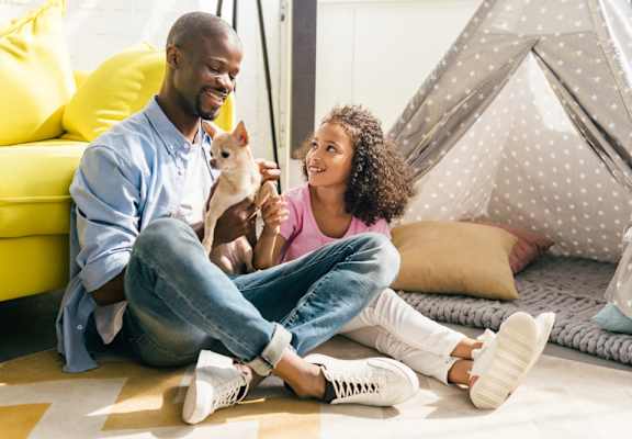 young couple sitting on the floor with their dog