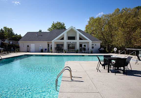 A pool with a slide and a house in the background.
