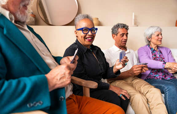 Four people sitting on a couch looking at their phones.