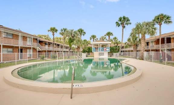 A pool in the middle of a courtyard surrounded by buildings.