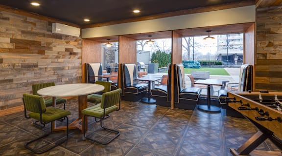 a club room with tables and chairs and a shuffleboard