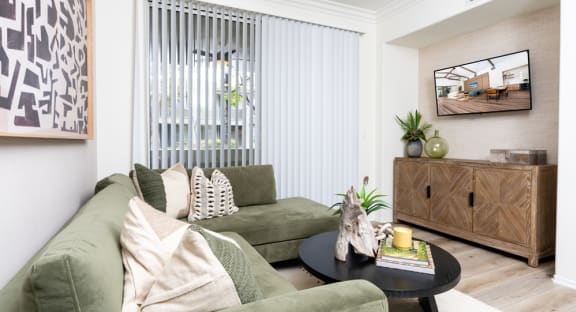 a living room with green couches and a coffee table
