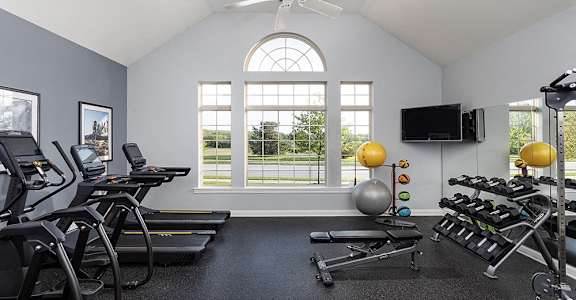 the gym has plenty of exercise equipment and a large window