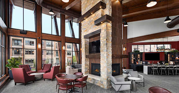A large room with a fireplace and chairs.