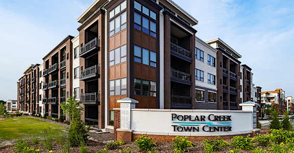 A multi-story building with a sign that says "Poplar Creek Town Center.".