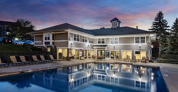 a large swimming pool with a house in the background