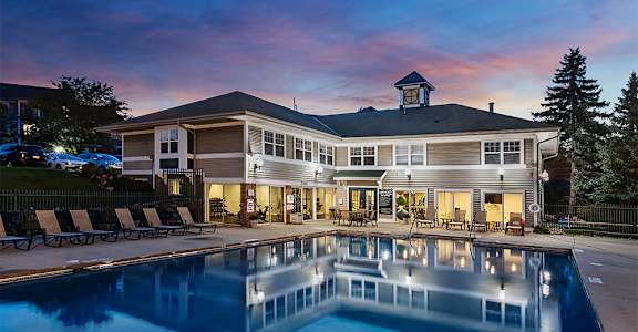 the pool at the residence at dusk with a building in the background
