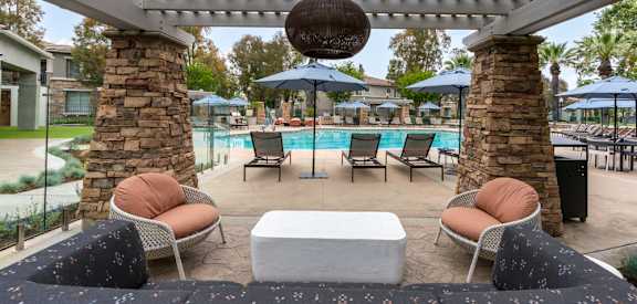 a poolside lounge area with chairs and a table