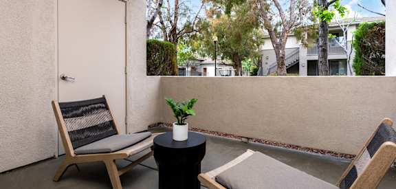 a balcony with two chairs and a table and a door
