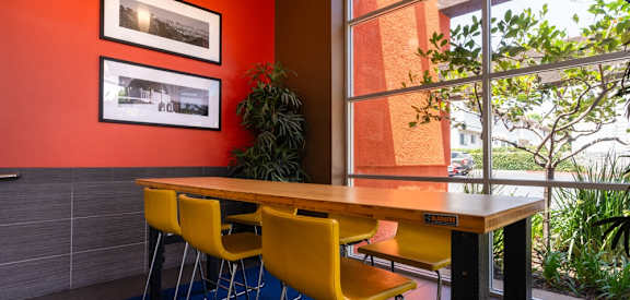 a dining room with yellow chairs and a wooden table