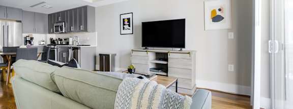 a living room with a couch a coffee table and a tv on the wall