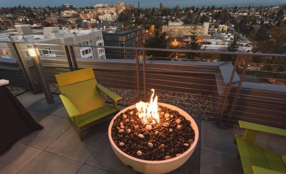 a fire pit on a roof with a city in the background