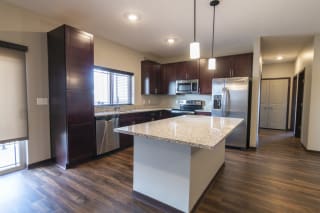 Kitchen with updated stainless steel appliances and pendant lighting above the island at 360 at Jordan West
