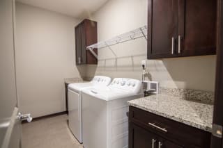 Laundry room with storage space, counter space, and a washer and dryer at 360 at Jordan West