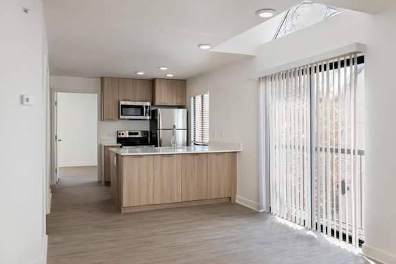 A kitchen with a refrigerator, microwave, and oven.