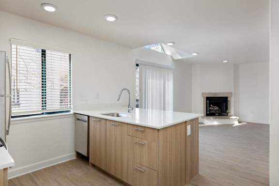 A modern kitchen with wooden cabinets and a white countertop.