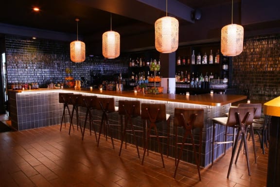 a bar with bar stools and lights in a restaurant